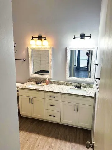 a bathroom with double sink and a mirror
