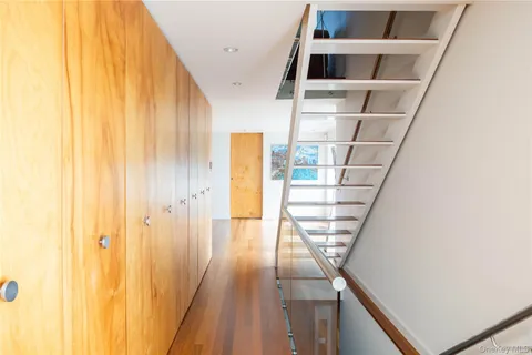 a view of a hallway with wooden floor and staircase