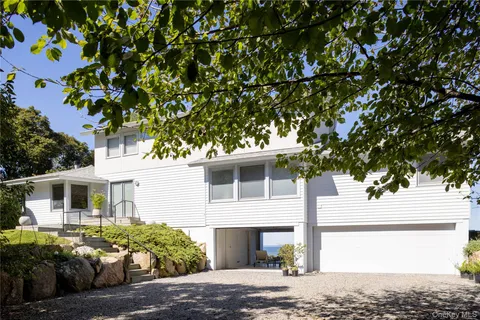 a front view of a house with a tree