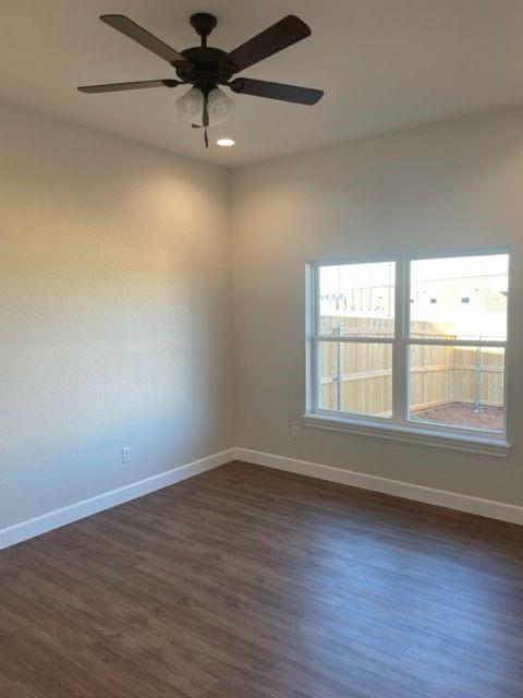7326 Mountain View Road, Unit 7328 Abilene, TX 79602 - Photo 11 of 15 an empty room with wooden floor fan and windows
