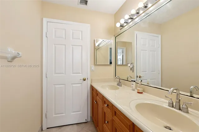 a bathroom with a double vanity sink and a mirror