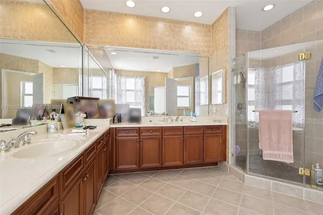 a large bathroom with a double vanity sink a large mirror and a shower