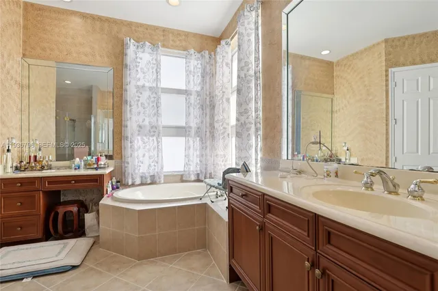 a spacious bathroom with a tub sink and mirror