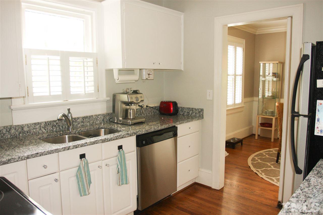726 Kimbrough Street Raleigh, NC 27608 - Photo 8 of 18 a kitchen with granite countertop a sink cabinets stainless steel appliances and a window