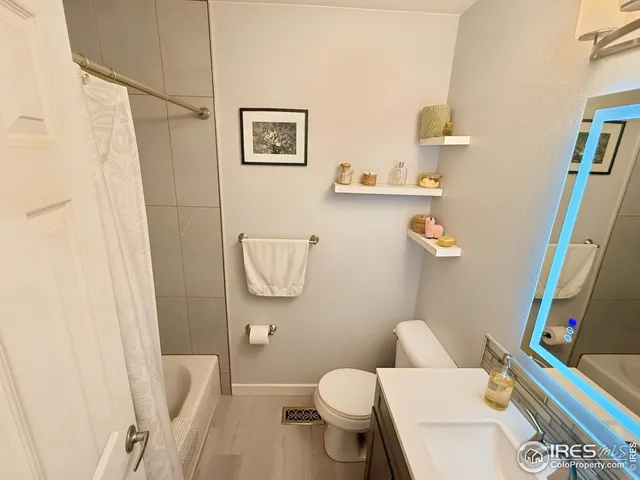 a white toilet sitting next to a bathroom sink and a mirror