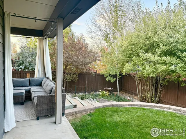 a view of a patio with couches table and chairs and a large tree