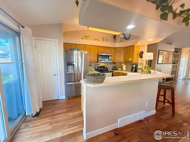 a room with stainless steel appliances kitchen island granite countertop a refrigerator and a stove top oven