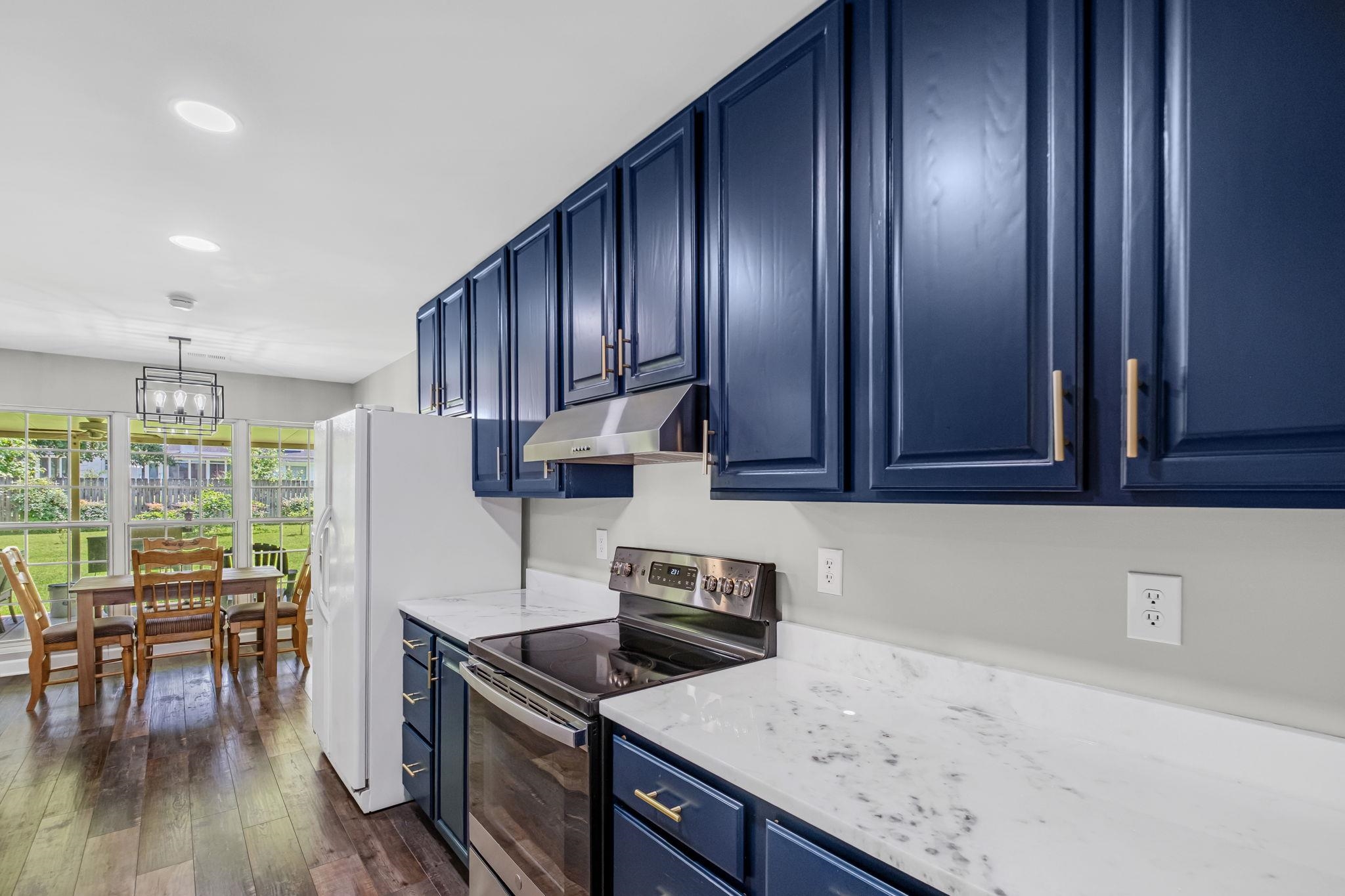 4729 Cedar Ridge Drive Millington, TN 38053 - Photo 10 of 40 Kitchen featuring blue cabinetry with gold-tone hardware, white marble-look countertops, and stainless steel appliances
