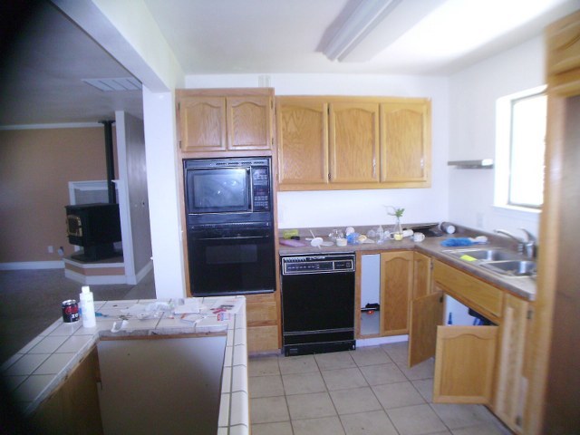 15890 West Wallen Road Red Bluff, CA 96080 - Photo 3 of 7 a kitchen with granite countertop a stove top oven cabinets and a refrigerator