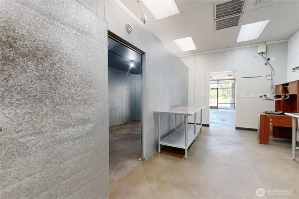 an empty room with windows and ceiling fan