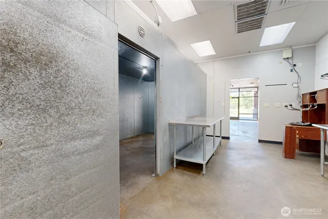 an empty room with windows and ceiling fan