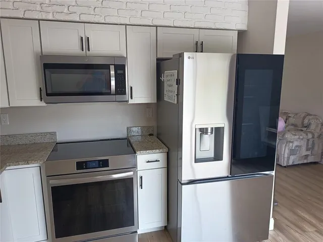 a kitchen with stainless steel appliances a stove microwave and refrigerator