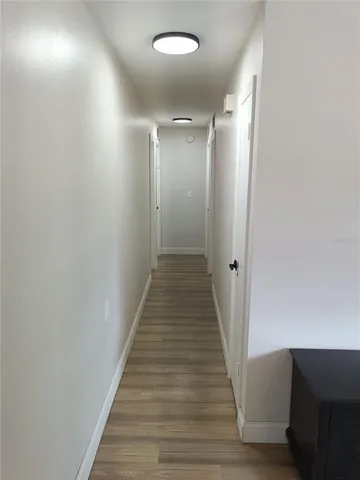 a view of a hallway with wooden floor
