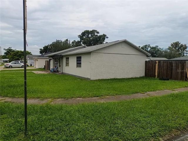 a view of a yard in front of a house with a large tree