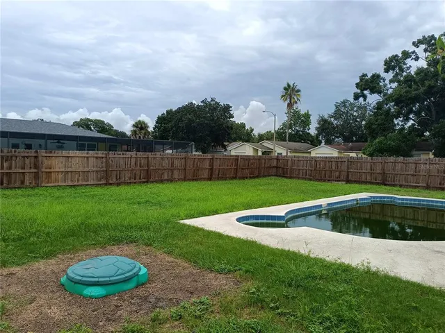 a view of outdoor space with swimming pool and trees in the background