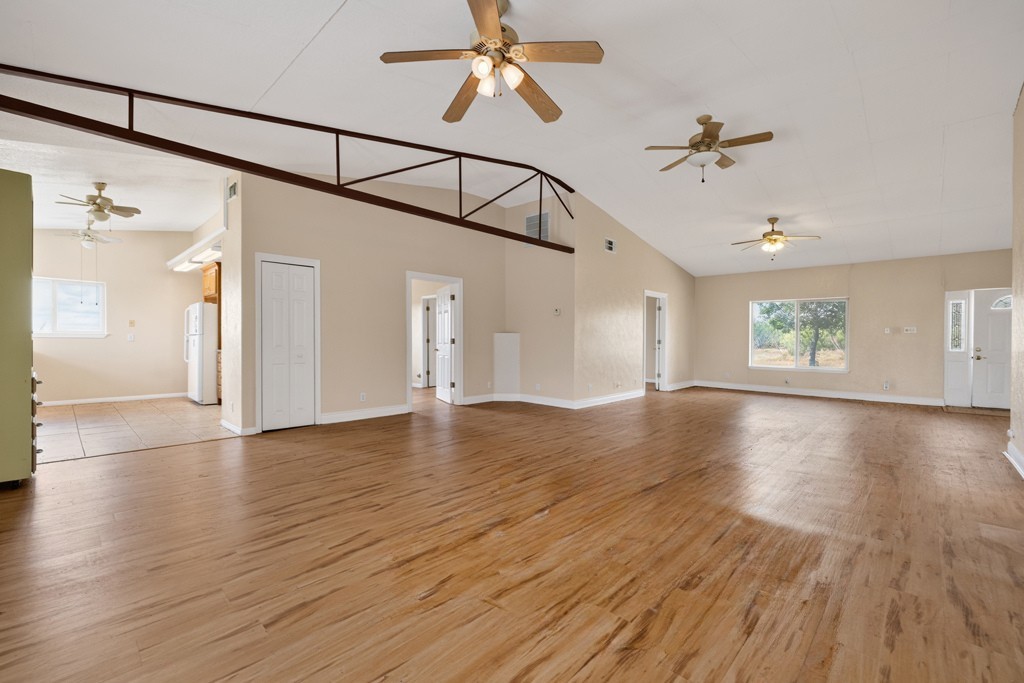 8804 Williamson Road Buda, TX 78610 - Photo 10 of 37 Warm wood flooring and vaulted ceilings create an open, airy feel in this spacious room.