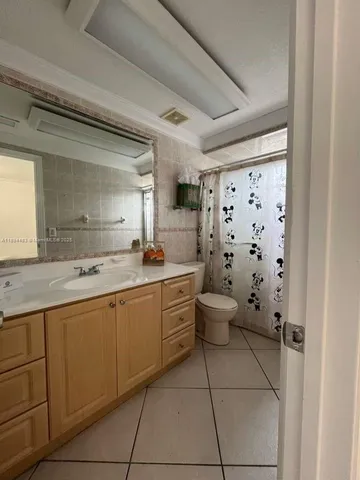 a bathroom with a granite countertop sink a toilet a mirror and shower