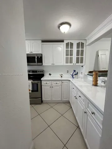 a kitchen with cabinets appliances a sink and a window