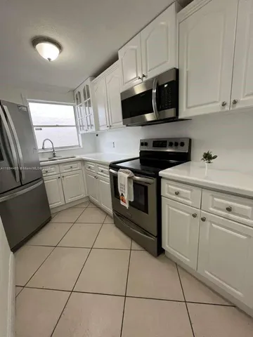 a kitchen with stainless steel appliances granite countertop a sink dishwasher stove top oven and cabinets