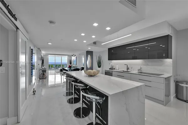 a kitchen with kitchen island a sink stove and refrigerator