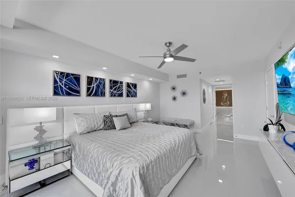 a spacious bedroom with a large bed and a chandelier