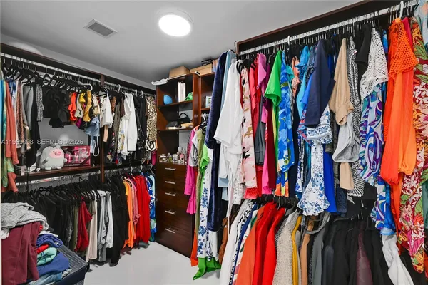 a view of walk in closet with clothes