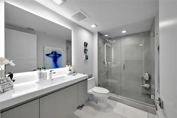 a bathroom with a double vanity sink toilet and shower