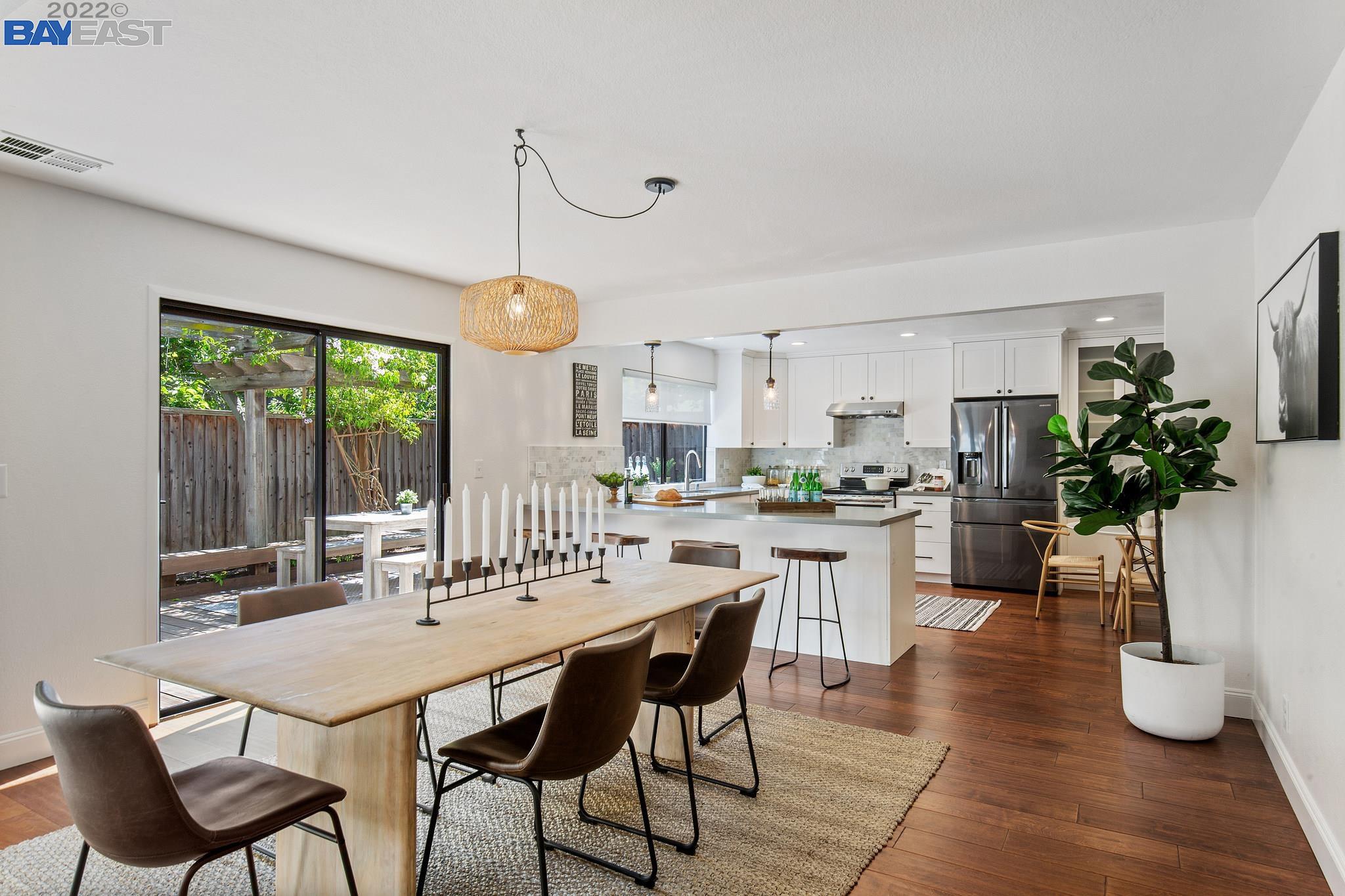 a dining room with furniture potted plants and wooden floor