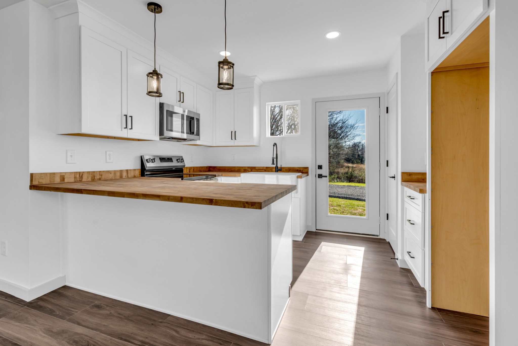 7159 C C C Road Fairview, TN 37062 - Photo 53 of 83 a kitchen with stainless steel appliances granite countertop a sink a stove and a wooden floor