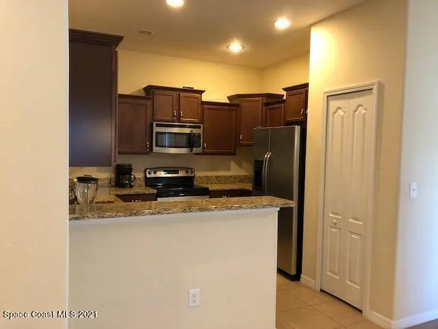 a kitchen with stainless steel appliances granite countertop a refrigerator and a stove top oven