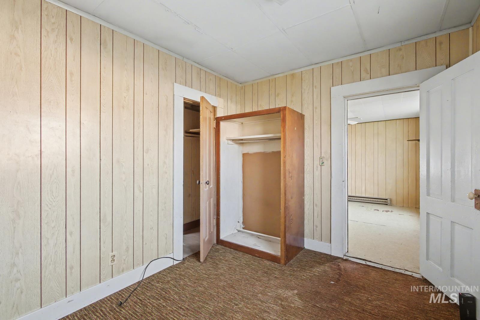332 High Street Pomeroy, WA 99347 - Photo 6 of 23 Unfurnished bedroom with wooden walls, carpet flooring, and baseboard heating