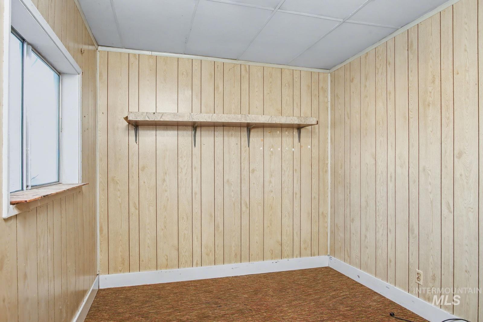 332 High Street Pomeroy, WA 99347 - Photo 7 of 23 Unfurnished room featuring wood walls and dark colored carpet
