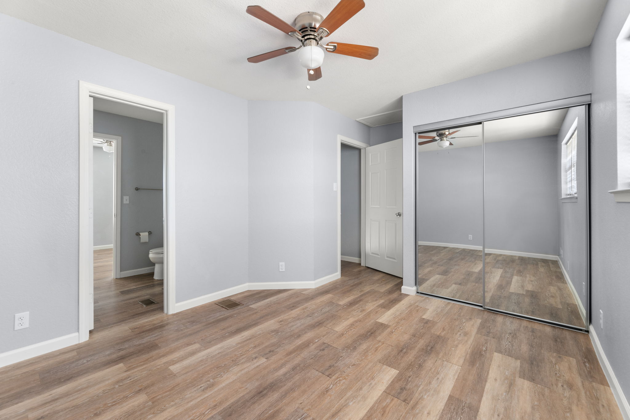 3802 Foust Trail, Unit A Georgetown, TX 78628 - Photo 23 of 34 Ample space for rest and rejuvenation awaits, featuring wide plank flooring and mirrored closet doors.