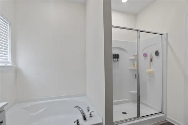 a bathroom with a tub a sink double vanity and mirror