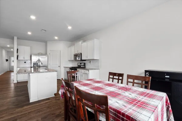 a kitchen with a table chairs refrigerator and cabinets