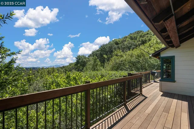 a balcony of a house with wooden floor and outdoor seating