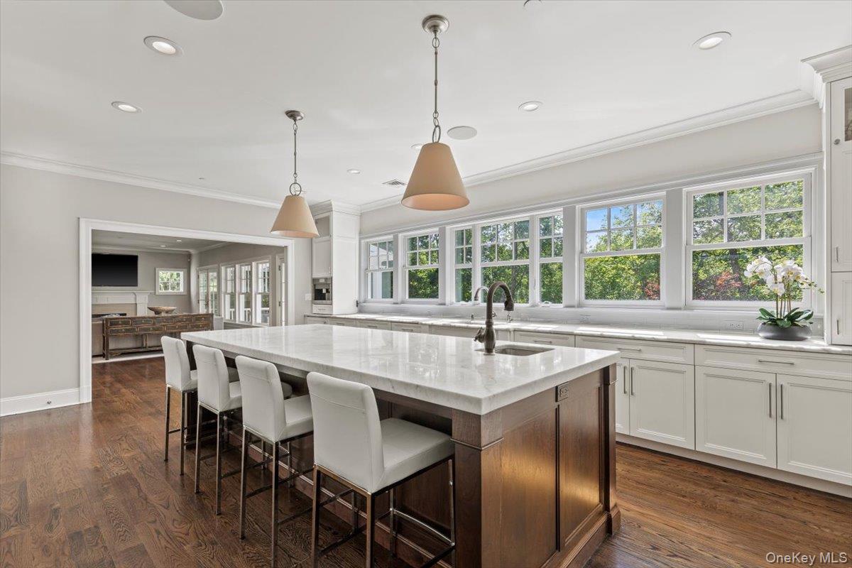 81 Wappanocca Avenue Rye, NY 10580 - Photo 9 of 27 Kitchen featuring ornamental molding, light stone counters, white cabinets, an island with sink, and recessed lighting