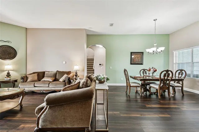 a kitchen with stainless steel appliances kitchen island granite countertop a table chairs and a refrigerator
