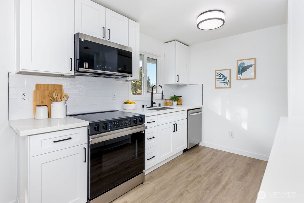 1103 Vashon Court Northeast Renton, WA 98059 - Photo 10 of 26 a kitchen with cabinets stainless steel appliances and wooden floor