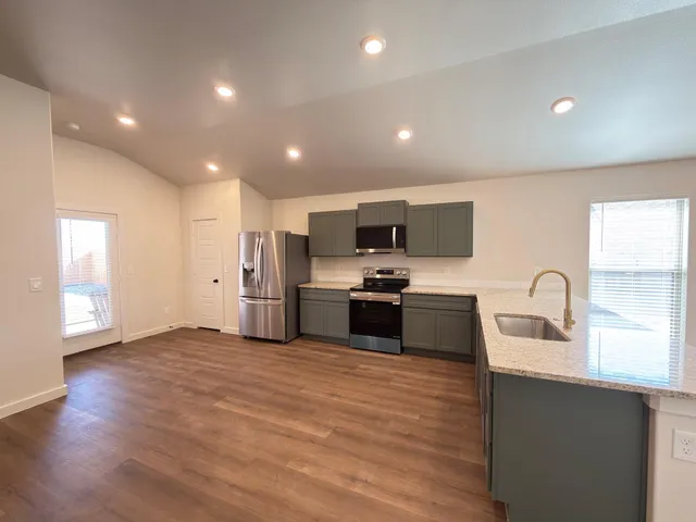 a kitchen with stainless steel appliances a refrigerator sink and microwave