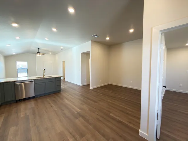 a large room with wooden floor and a sink