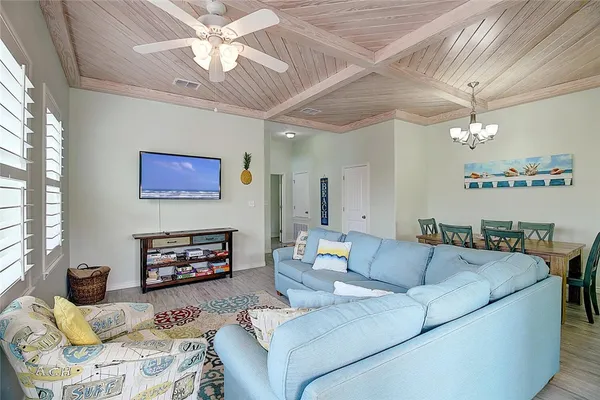 a living room with furniture a fireplace and a ceiling fan