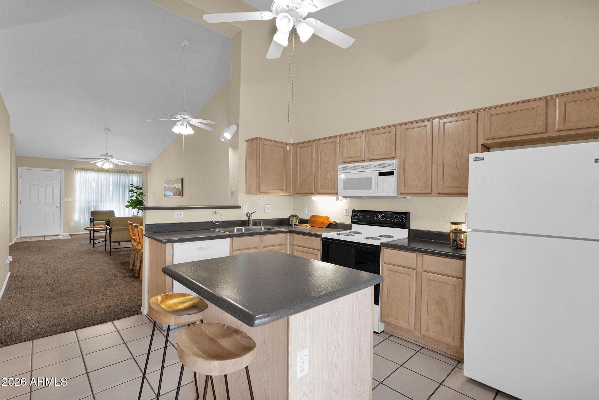 5808 East Brown Road, Unit 36 Mesa, AZ 85205 - Photo 10 of 29 a kitchen with a sink a stove a refrigerator and white cabinets