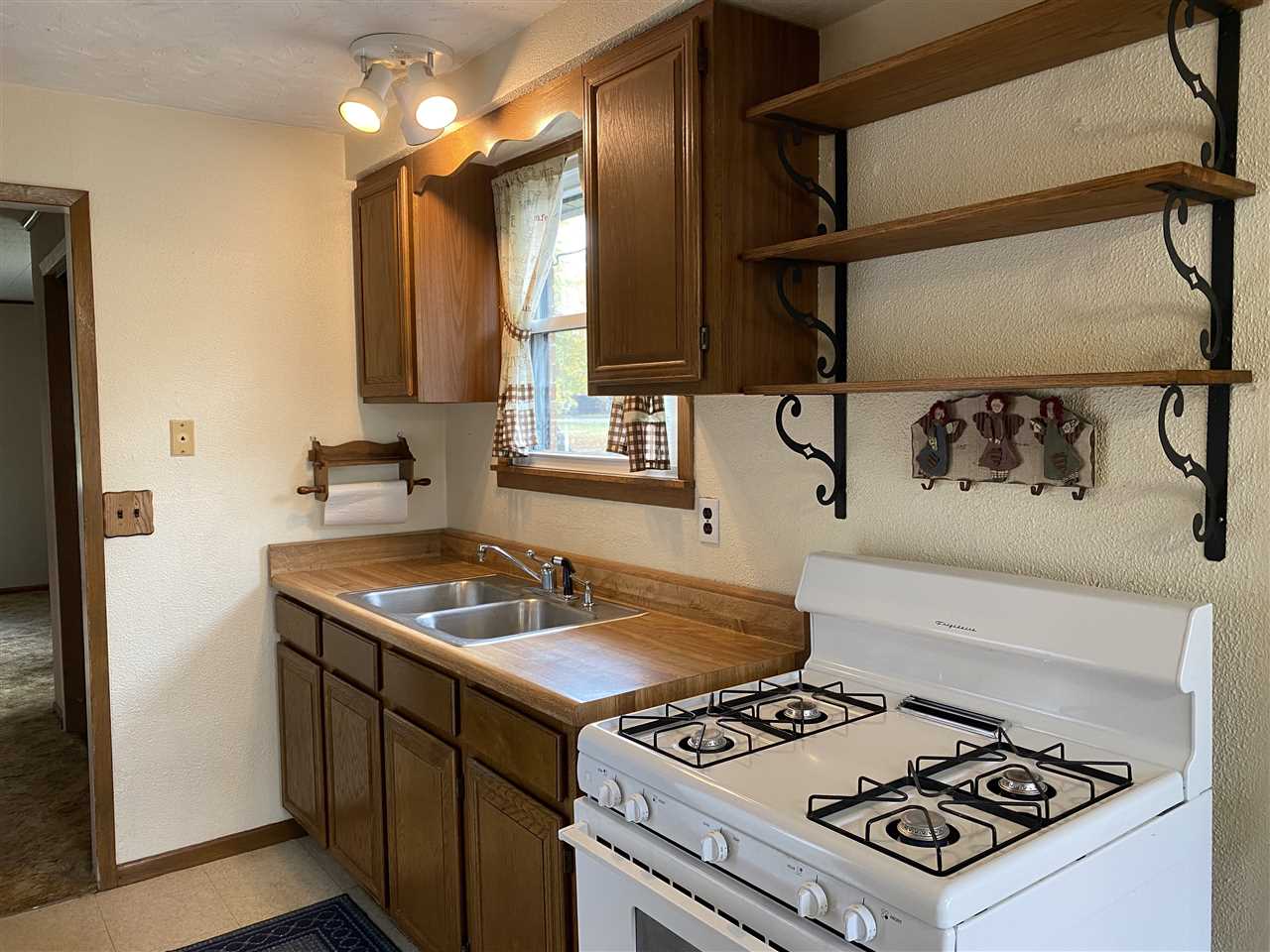 10979 2nd Street Roscoe, IL 61073 - Photo 14 of 30 a kitchen with a stove a sink and a refrigerator