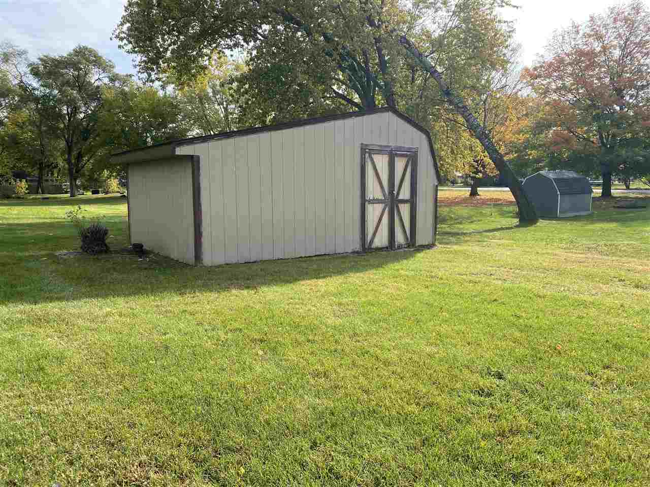 10979 2nd Street Roscoe, IL 61073 - Photo 28 of 30 a backyard of a house with large trees and brick wall