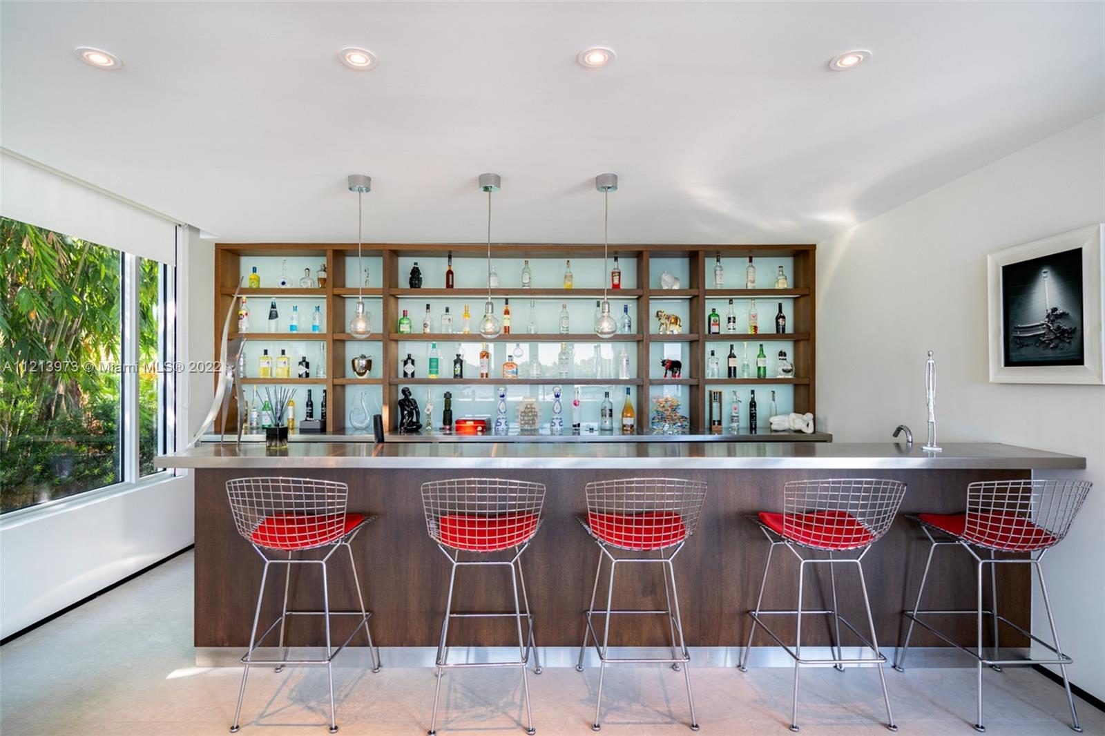 1236 Biscaya Drive Surfside, FL 33154 - Photo 15 of 40 a kitchen with stainless steel appliances kitchen island granite countertop a dining table and chairs
