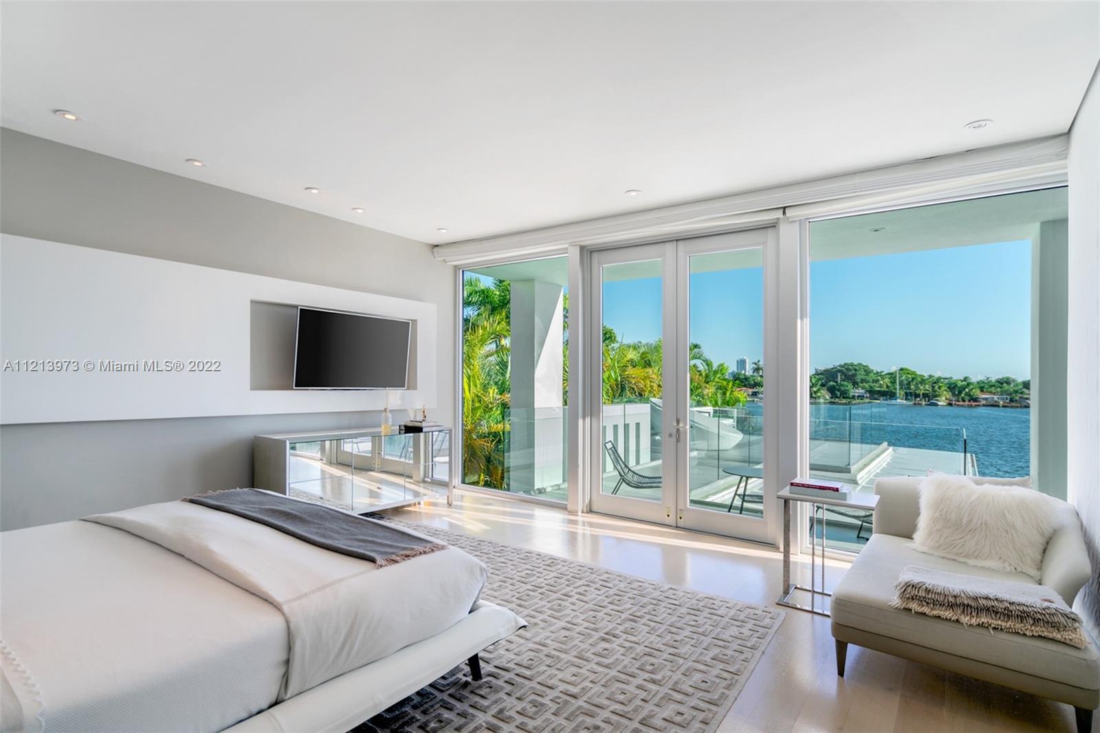 1236 Biscaya Drive Surfside, FL 33154 - Photo 21 of 40 a bedroom with a bed and glass window