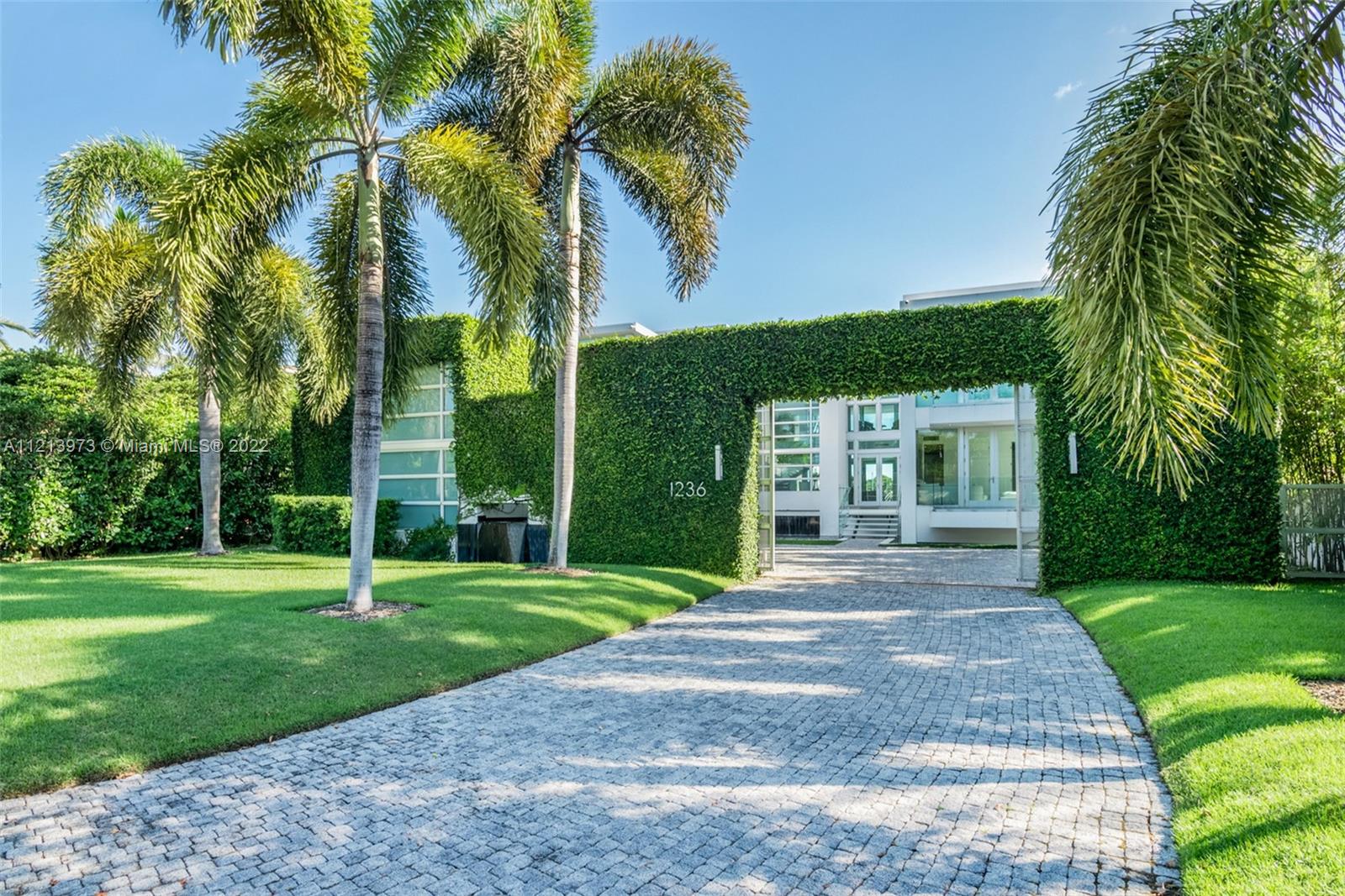 1236 Biscaya Drive Surfside, FL 33154 - Photo 32 of 40 a front view of a house with garden and trees