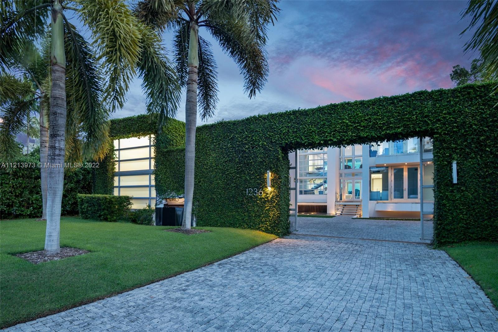 1236 Biscaya Drive Surfside, FL 33154 - Photo 7 of 40 a front view of a house with a garden and yard