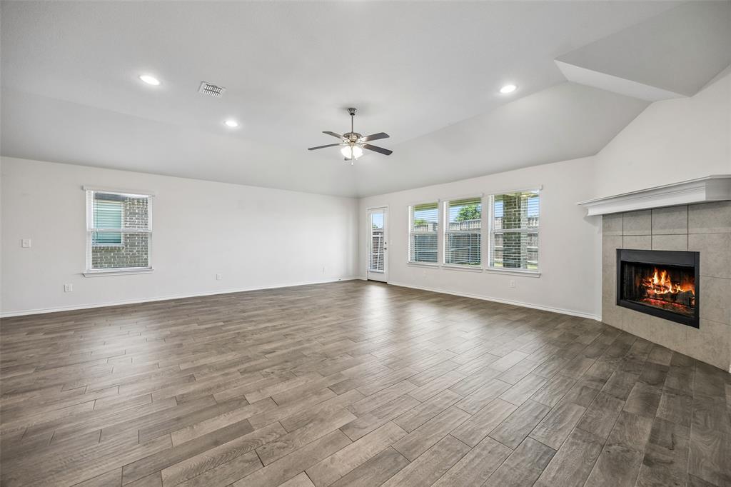 3807 Dogwood Road Melissa, TX 75454 - Photo 16 of 38 an empty room with windows fireplace and a kitchen view